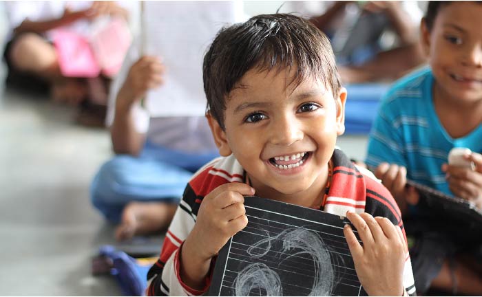 Boy smiling and holding a sign